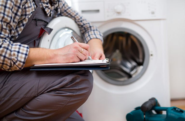 Repair technician inspecting a washing machine